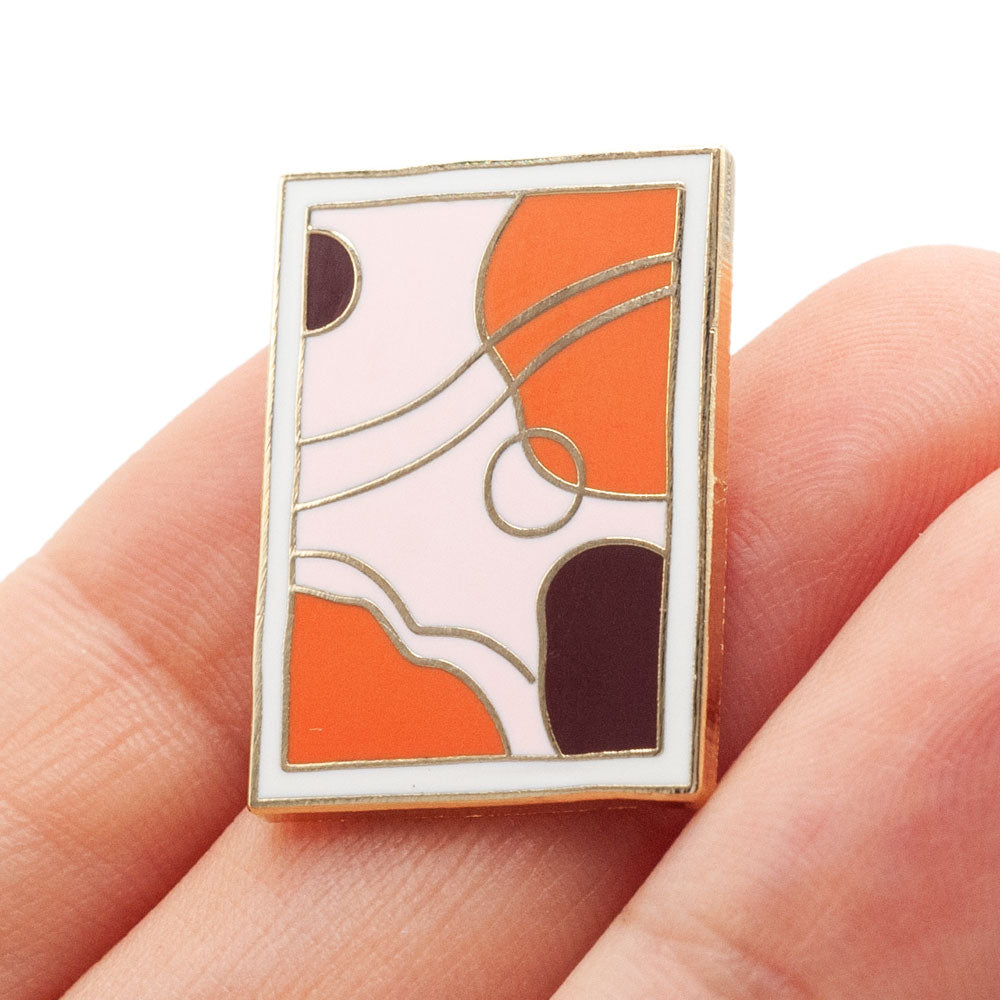 mid-century modern art piece. light pink, orange, plum and white colors in gold enamel. Closeup of pin